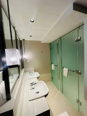 a bathroom with two sinks and a shower at Novotel Suites Manila Aqua Residences Near Makati by Hamodi'sCrib in Manila