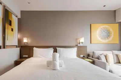 a bedroom with a large white bed and a couch at Novotel Suites Manila Aqua Residences Near Makati by Hamodi'sCrib in Manila