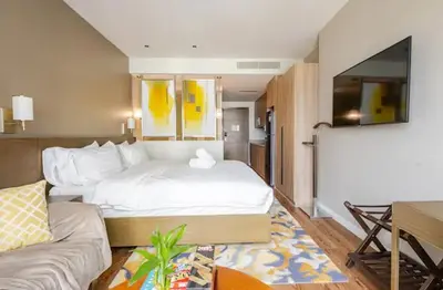 a hotel room with a bed and a couch at Novotel Suites Manila Aqua Residences Near Makati by Hamodi'sCrib in Manila