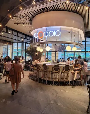 a restaurant with people sitting around a table in a building at Staycations Up Above 13 at BGC in Manila