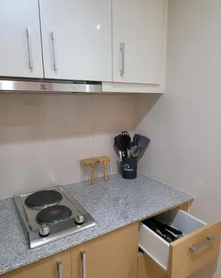 a kitchen with a stove and a cup of utensils at Staycations Up Above 13 at BGC in Manila