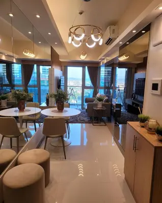 a lobby with tables and chairs in a building at Uptown Parksuites Tower 2 BGC - Staycations Up Above 9 in Manila