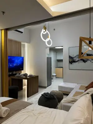 a bedroom with two beds and a flat screen tv at One Uptown Residences at BGC - Staycations Up Above 15 in Manila