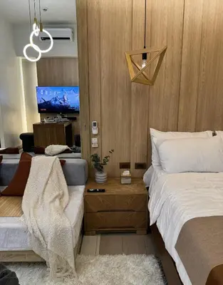 a bedroom with a bed and a nightstand with a bed sidx sidx at One Uptown Residences at BGC - Staycations Up Above 15 in Manila