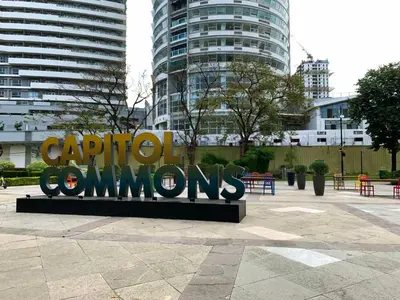 a large metal sign in a city with buildings at Budget Family Room at Ace Suites by the Famous Indoor Water Spa in Manila