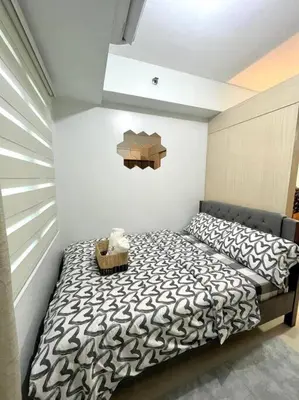 a bedroom with a bed with a black and white comforter at Sea Residences by Richnells in Manila