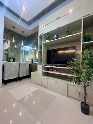 a dining room with a large television and a table at Sea Residences by Richnells in Manila
