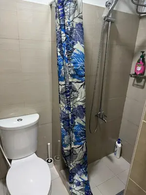 a bathroom with a toilet and a shower curtain at Nordic Style - 2BR Shore 2 Residences Tower 2 in Manila