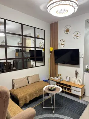 a living room with a couch and a flat screen tv at Nordic Style - 2BR Shore 2 Residences Tower 2 in Manila