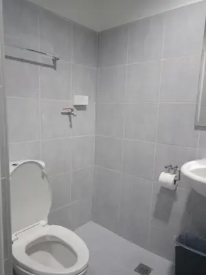 a bathroom with a toilet and a sink at Reynas place at sea residences in Manila