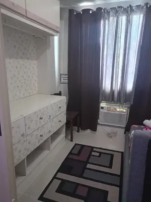 a bedroom with a bed and a window with curtains at Reynas place at sea residences in Manila