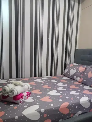a bedroom with a bed with a pink and white polka dots at Reynas place at sea residences in Manila