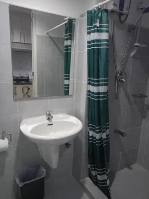 a bathroom with a sink and a shower curtain at Reynas place at sea residences in Manila