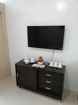 a black entertainment center with a television on a wall at Mall of Asia Sea Residences Staycation Pasay City in Manila
