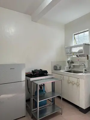 a small kitchen with a stove and a refrigerator at 2 StoryHome in Tanza near SM along Main Road in Tanza