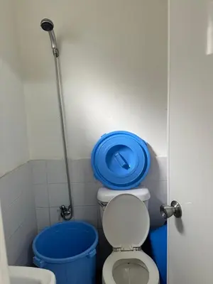 a bathroom with a toilet with a blue lid on it at 2 StoryHome in Tanza near SM along Main Road in Tanza