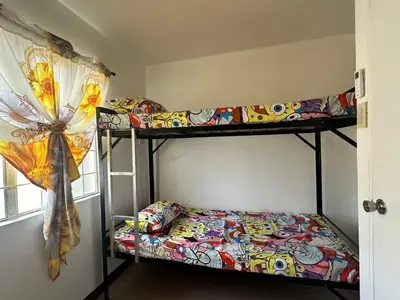 a bedroom with two bunk beds and a window at 2 StoryHome in Tanza near SM along Main Road in Tanza