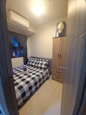 a small bedroom with a bed and a window at Kota S Residences in Manila