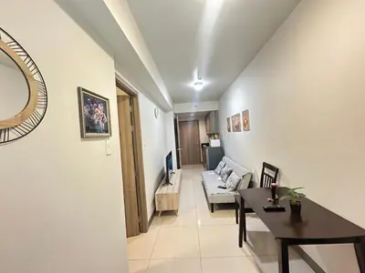 a living room with a couch and a table at Kota S Residences in Manila