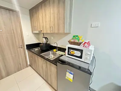 a small kitchen with a microwave on top of a refrigerator at Kota S Residences in Manila