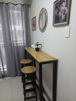 a table and two stools in a room with a mirror at Kota S Residences in Manila