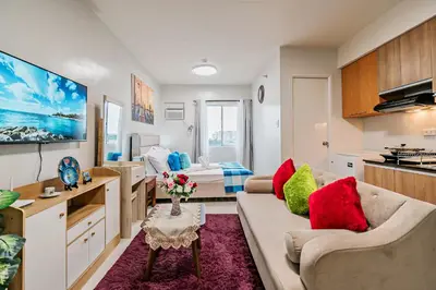 a living room with a couch and a kitchen at Precious Florannjoe in Manila