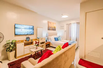 a bedroom with a bed and a couch in a room at Precious Florannjoe in Manila