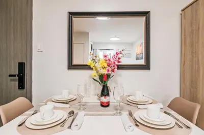 a dining room table with a mirror and a vase of flowers at Precious Florannjoe in Manila