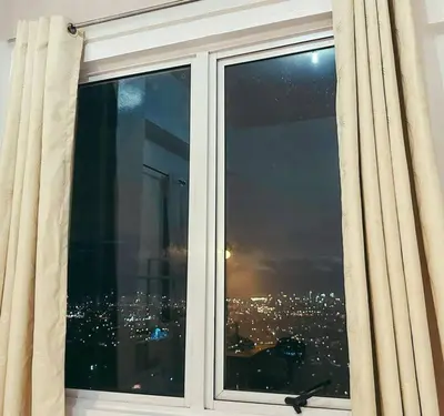 a window with a view of a city at night at Condo unit in Manda near Edsa, Shangrila, Megamall in Manila