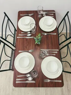 a wooden table with white plates and silverware on it at Condo unit in Manda near Edsa, Shangrila, Megamall in Manila