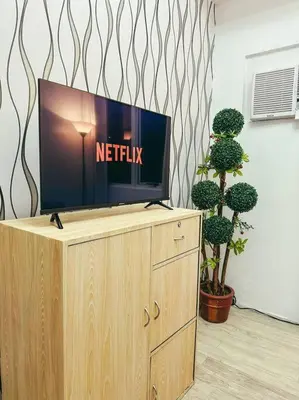 a tv on top of a wooden dresser with a television on it at Condo unit in Manda near Edsa, Shangrila, Megamall in Manila