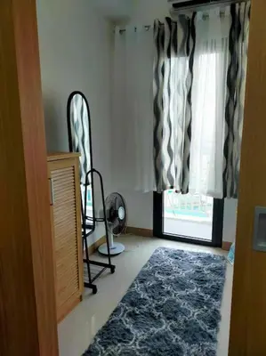 a living room with a chair and a window at Jireh's Staycation in Makati in Manila