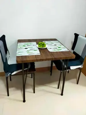 a wooden table with two chairs and a plate of food at Jireh's Staycation in Makati in Manila