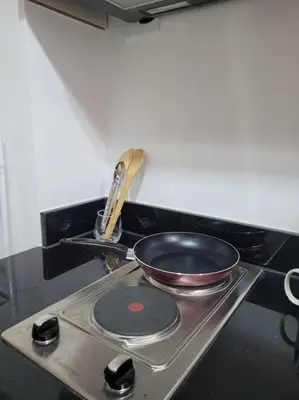 a frying pan sitting on top of a stove at Jireh's Staycation in Makati in Manila
