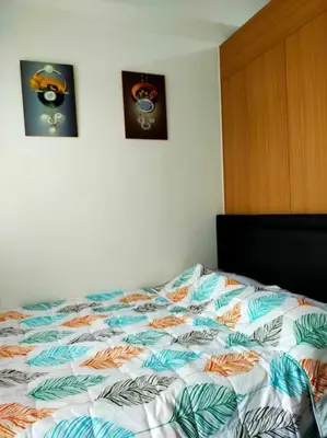 a bed in a bedroom with two pictures on the wall at Jireh's Staycation in Makati in Manila