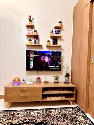 a living room with a flat screen tv on a wall at High Rise Condo with Balcony, Pool, Grand Lobby, and Sky Garden 22F in Manila
