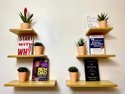 three shelves on a wall with books and plants at High Rise Condo with Balcony, Pool, Grand Lobby, and Sky Garden 22F in Manila