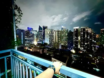 a person standing on a balcony looking at a city skyline at High Rise Condo with Balcony, Pool, Grand Lobby, and Sky Garden 22F in Manila
