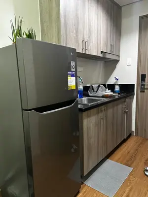 a kitchen with a black refrigerator and a sink at Casa Bella at S Residence, Near SM Mall of Asia in Manila