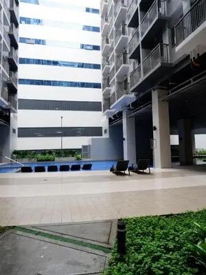 a large building with two chairs in a courtyard at Casa Bella at S Residence, Near SM Mall of Asia in Manila
