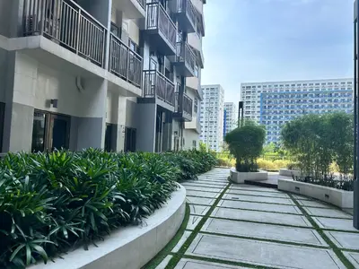 a walkway in front of a building with plants at Casa Bella at S Residence, Near SM Mall of Asia in Manila