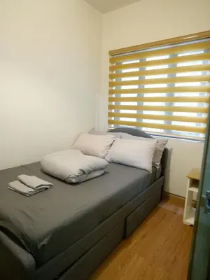 a bed with two pillows on it in a room with a window at Casa Bella at S Residence, Near SM Mall of Asia in Manila