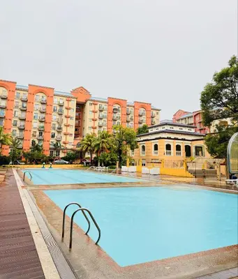 a large swimming pool in front of a building at Casa Luz Budget Condotel in Manila
