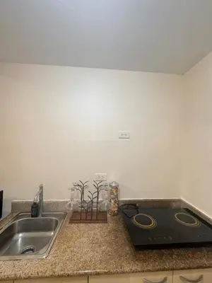 a kitchen counter with a sink and a stove at Casa Luz Budget Condotel in Manila