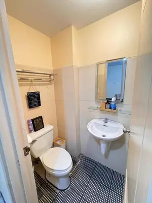 a bathroom with a white toilet and a sink at Casa Luz Budget Condotel in Manila