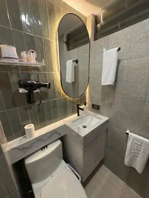 a bathroom with a toilet and a sink and a mirror at Mi Casa en Manila in Manila