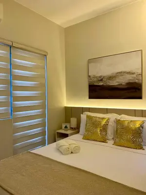 a bedroom with a large white bed with pillows at Casa Eleganza at Fame Residences - 1BR corner unit, CBD, Gym, Pool, WiFi, Great View in Manila