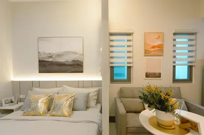 a living room with a bed and a couch at Casa Eleganza at Fame Residences - 1BR corner unit, CBD, Gym, Pool, WiFi, Great View in Manila