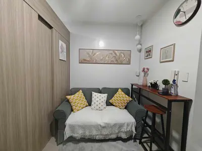 a living room with a couch with pillows on it at Zeki's Place - Shore 2 Residences MOA in Manila