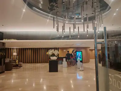 a lobby with people standing at a counter in a building at Zeki's Place - Shore 2 Residences MOA in Manila